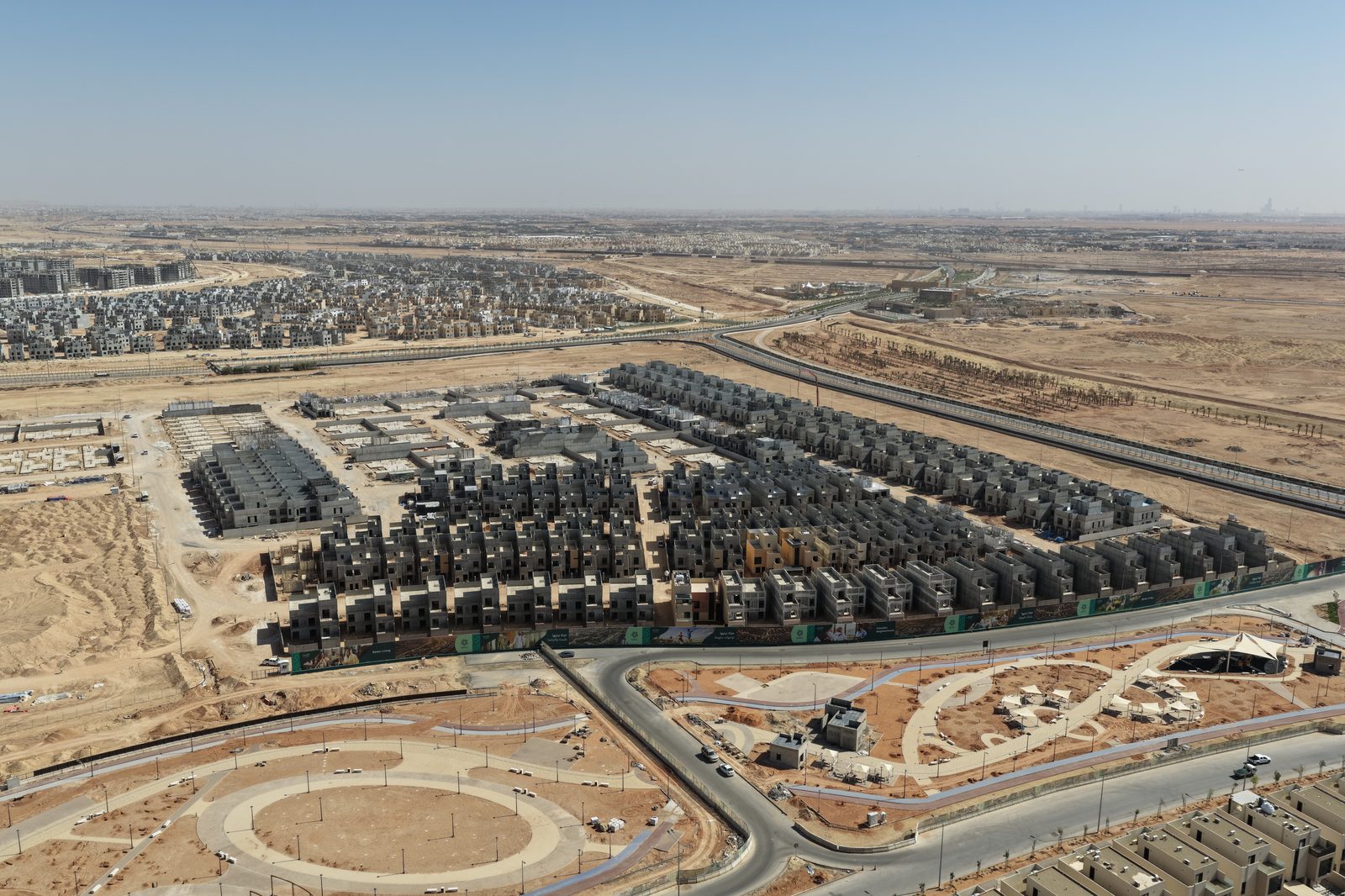Aerial view of the Ebayya project in Riyadh, showing rows of villas under construction beside completed roads and public spaces