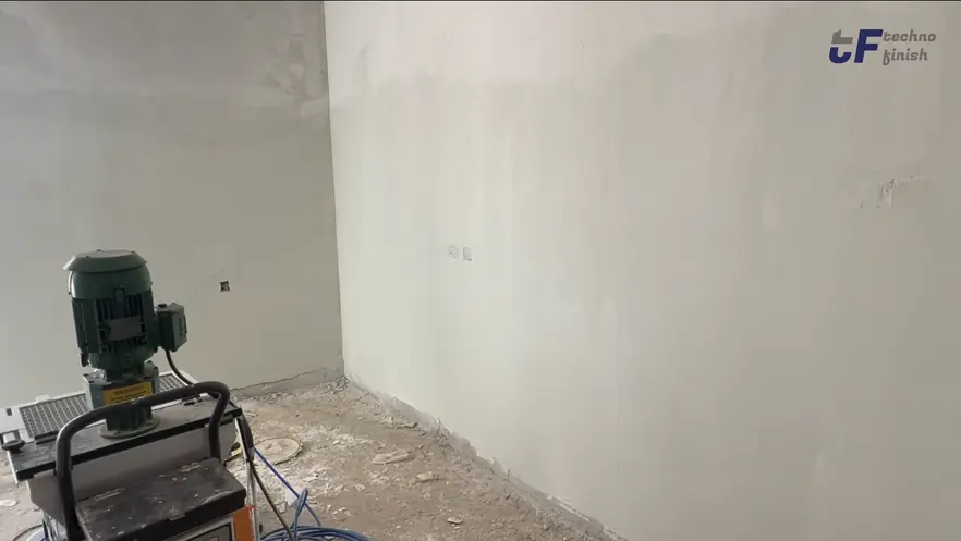 Mechanized wall-sanding equipment beside a prepared surface